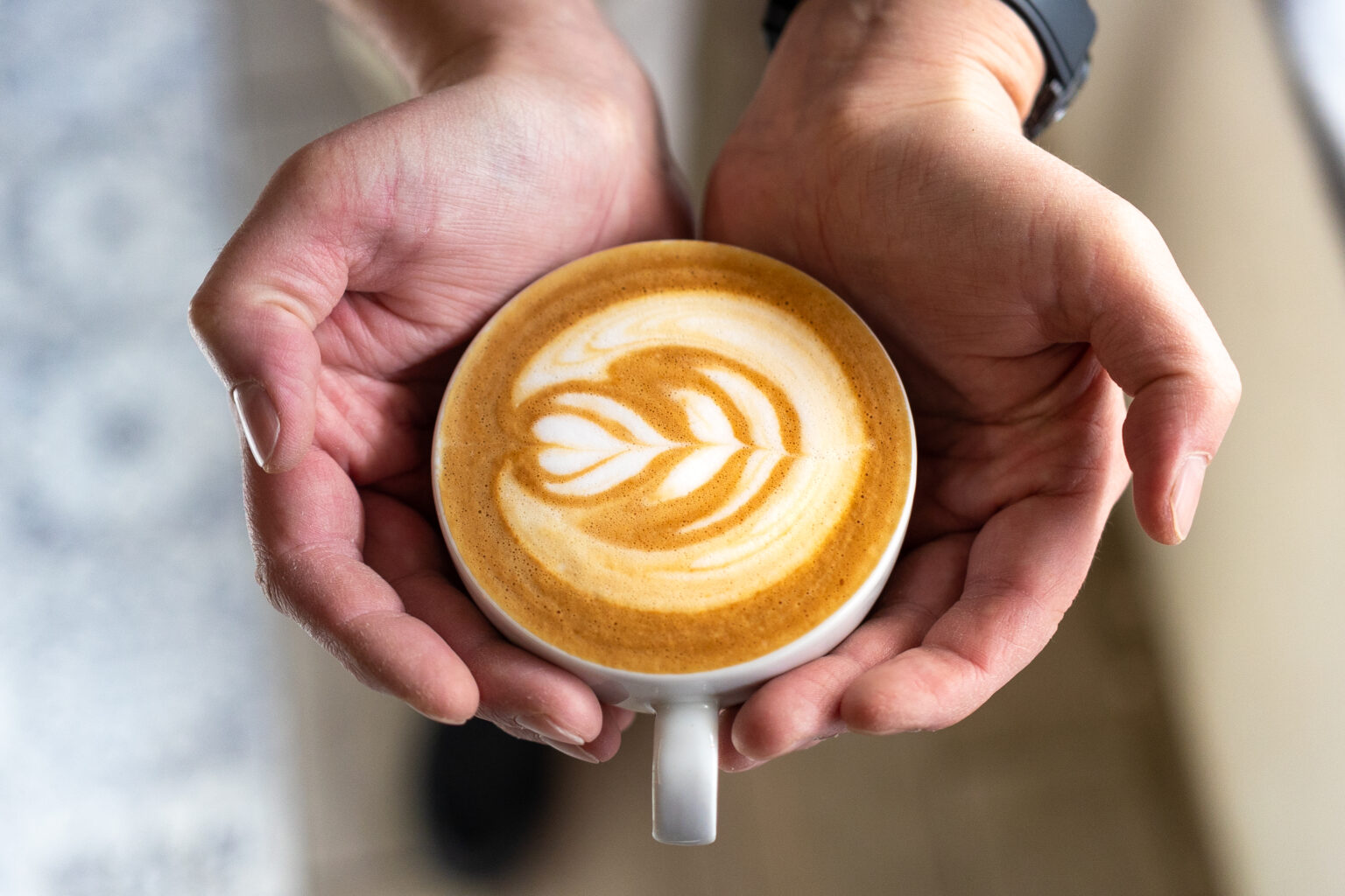 Cappuccino s latte artem v rukou
